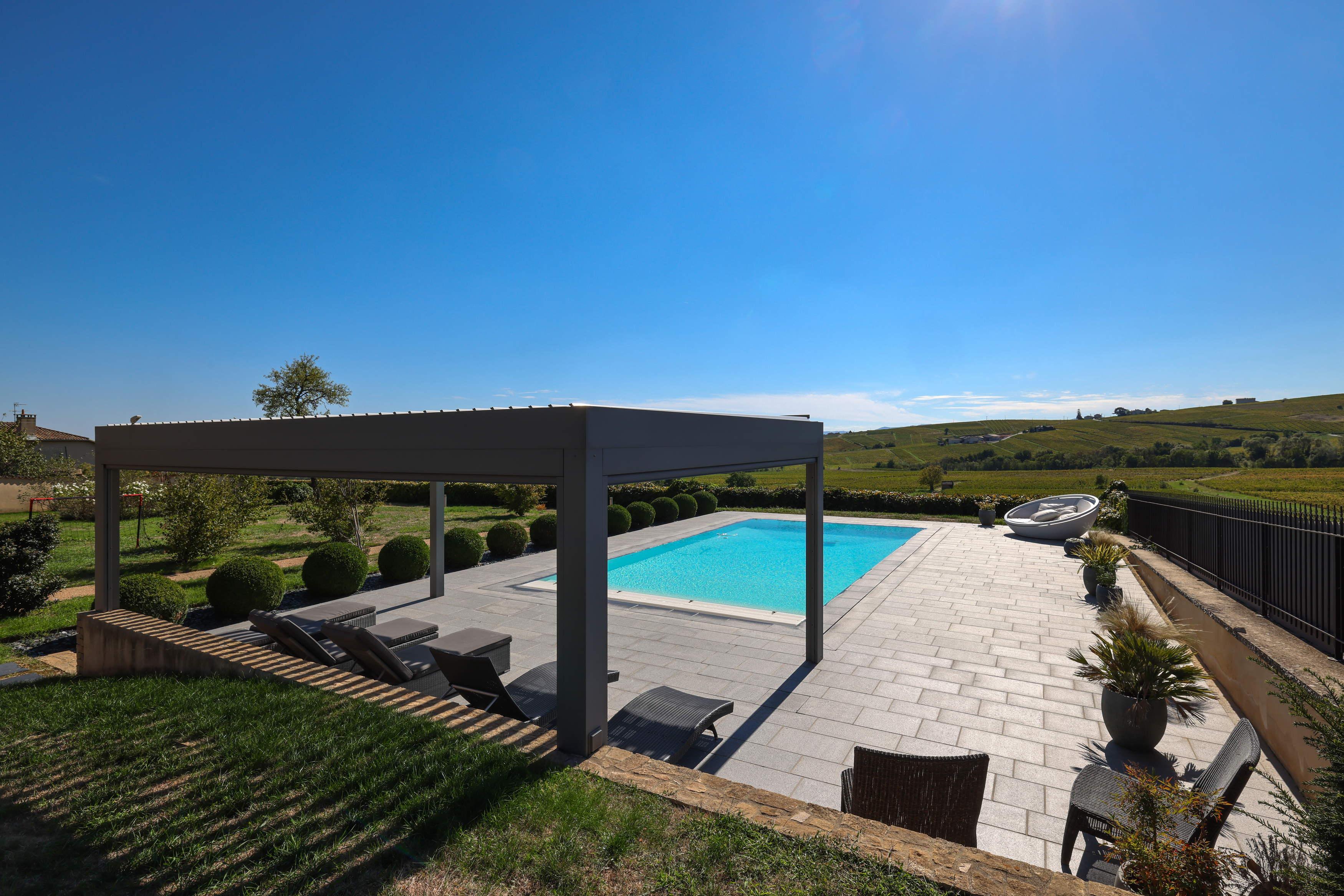 Bioclimatic pergola in front of a swimming pool 